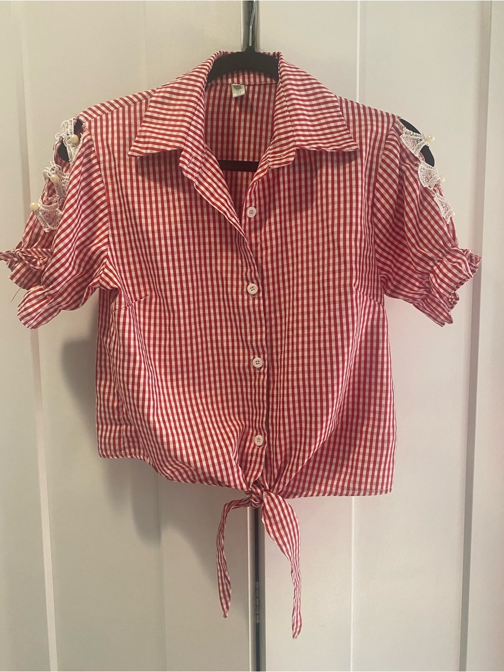 Red and white Daisy Duke checker shirt with tie and button detail on sleeves.